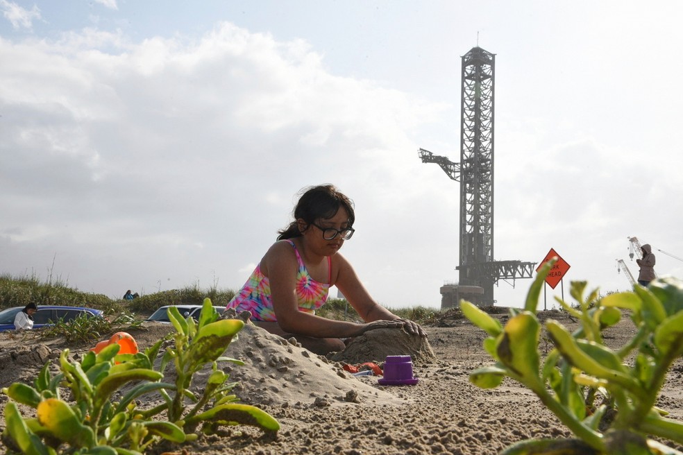 Criança brinca na praia de Boca Chica， no Texas， próximo à base de lançamento da SpaceX — Foto: AP Photo/Valerie Gonzalez